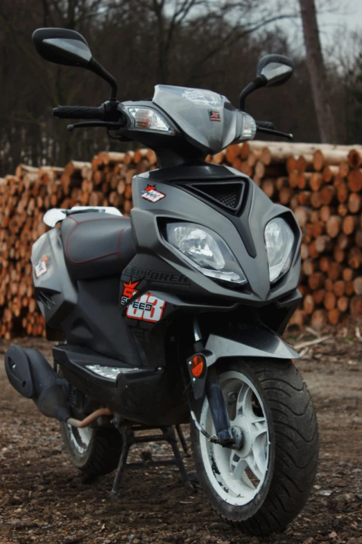 motorcycle parked near a pile of logs in dirt