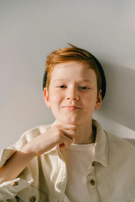 a little boy is standing in front of a wall