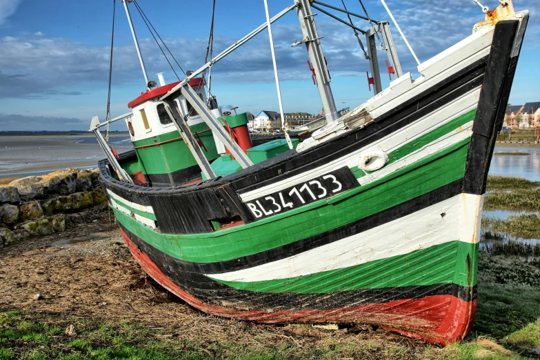 a small fishing boat rests next to a concrete wall