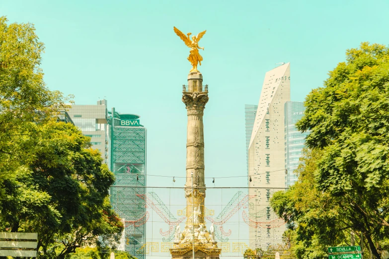 a statue and park in the city with lots of greenery