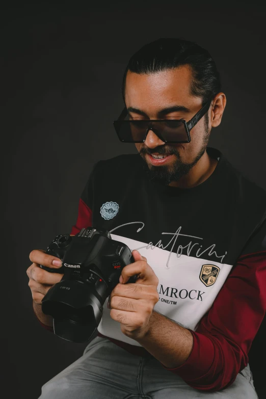 a man is holding a camera and sitting down