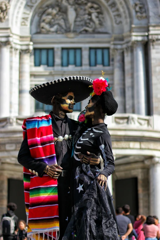 the man and woman are wearing costumes with their faces covered in colors