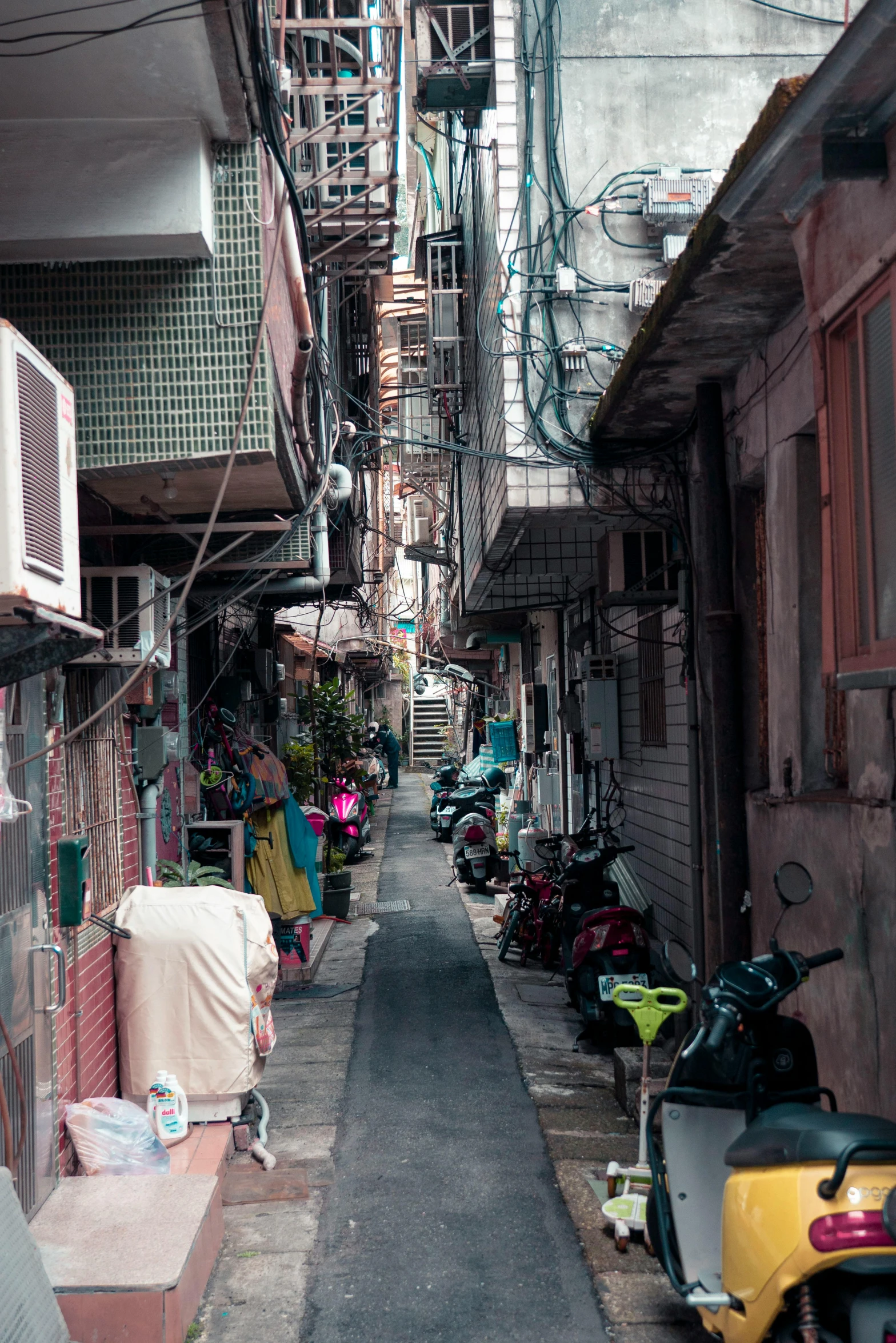 an alleyway with many scooters parked in rows