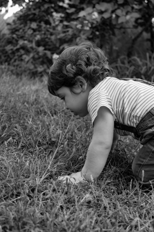 a little girl is playing with some grass