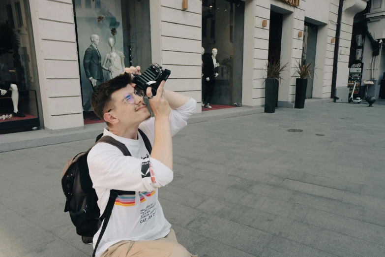 a boy in a white shirt is looking up at his hand through binoculars