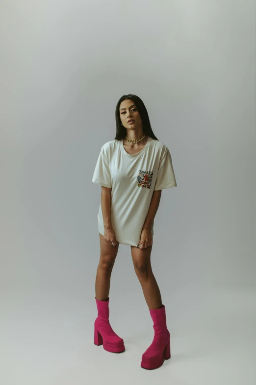 a woman standing on a white background in boots