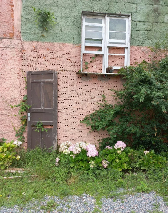 an old house that is sitting by a wall