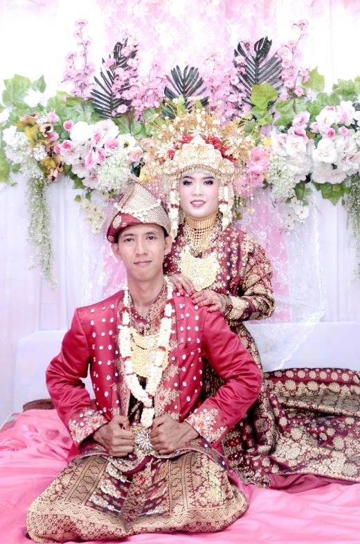 a couple dressed in traditional thai garb posing for a po