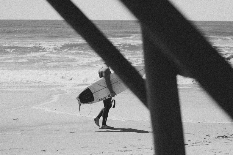 a man carrying a surfboard on top of a beach