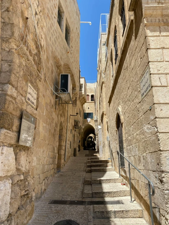 the view down an alley with stairs between two buildings