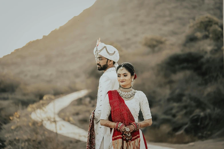 a bride and groom stand together on the road