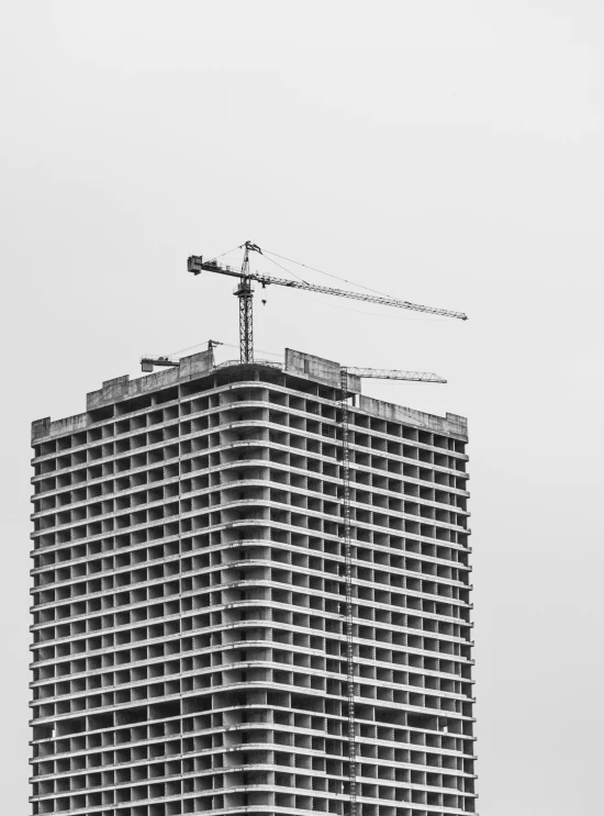 two cranes and some construction equipment on top of a building