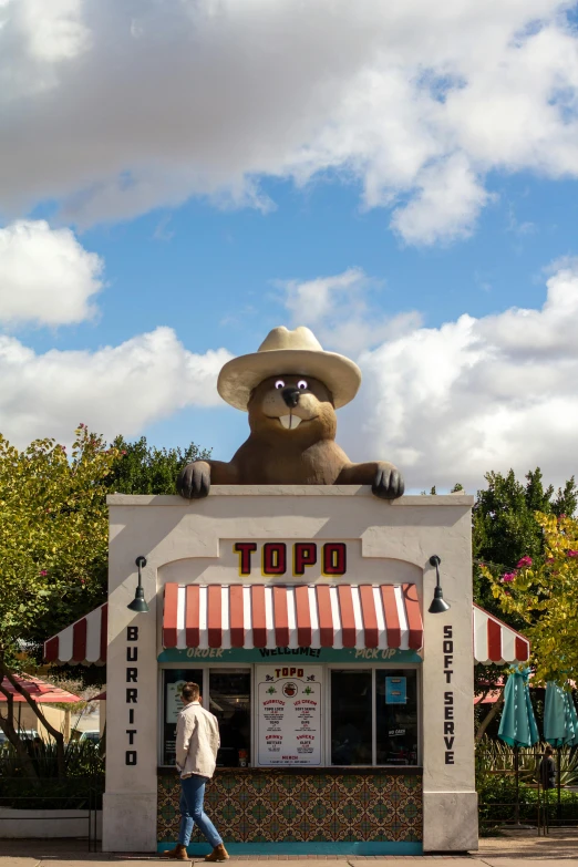 the big stuffed bear is on top of a restaurant