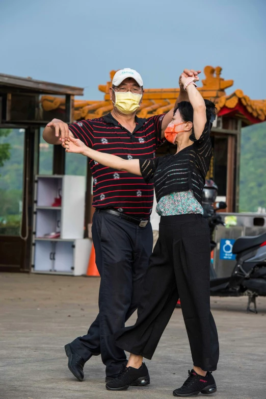 two people dance in front of a building