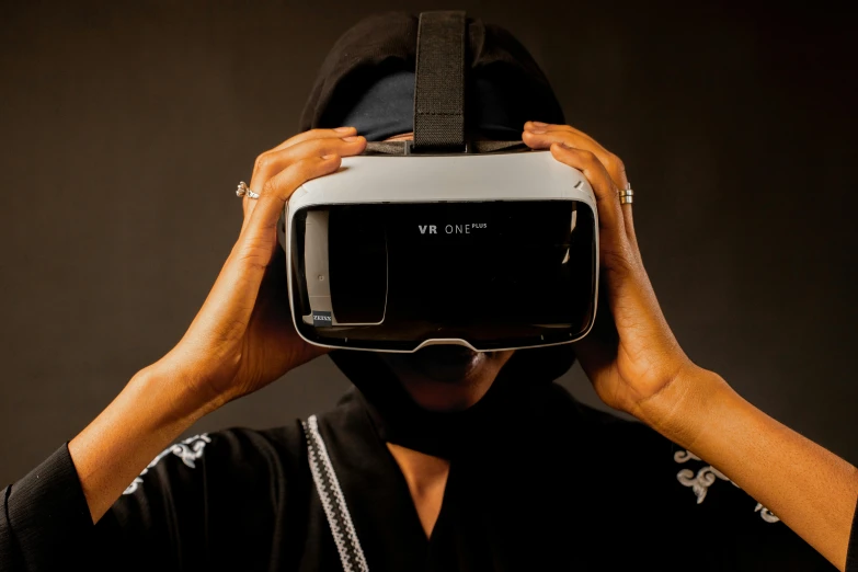 a man wearing a virtual reality headset while standing against a black background