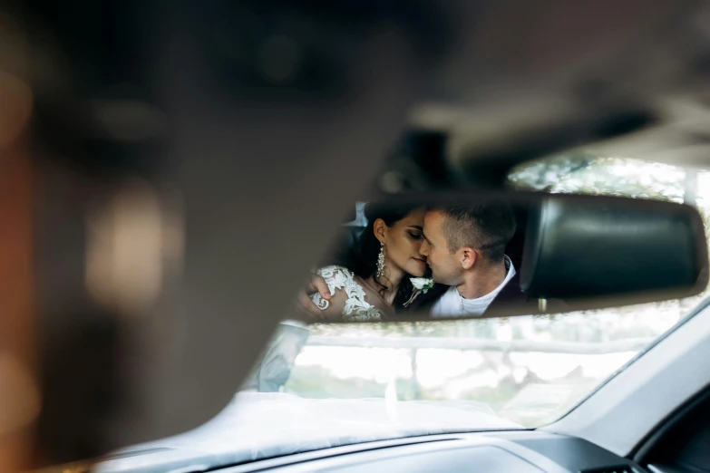 a bride and groom kissing in a car