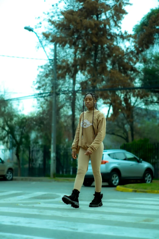 a person walking across the street in a parking lot