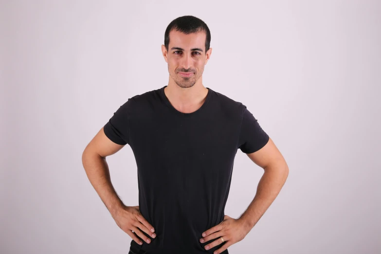 a man in black shirt and shorts posing with his hands on his hips