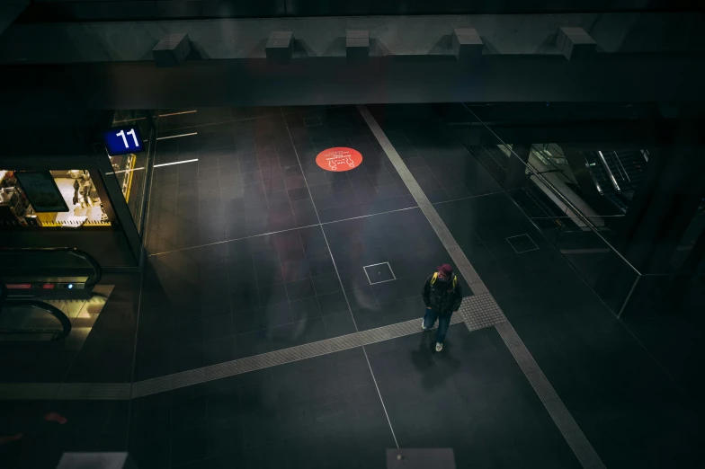 a person on a dark street with a red circle on the ground