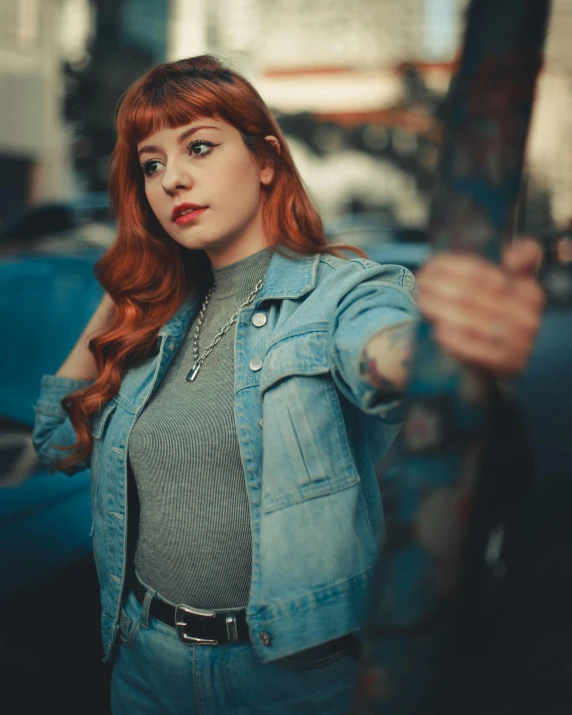 a woman is standing by a car and holding a large object