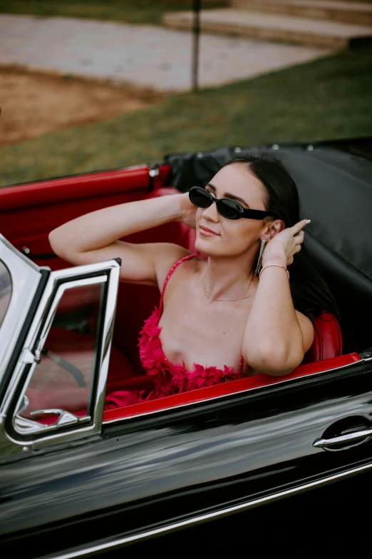 a woman is in a car wearing sunglasses