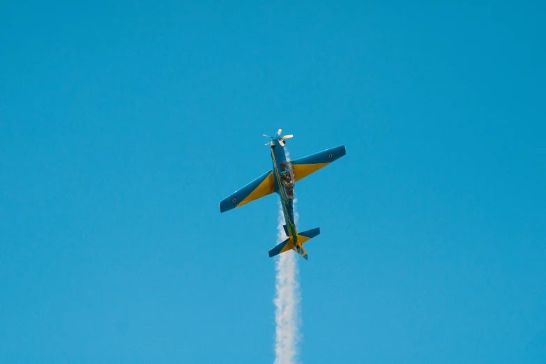 an airplane high in the air leaving a trail of smoke behind it