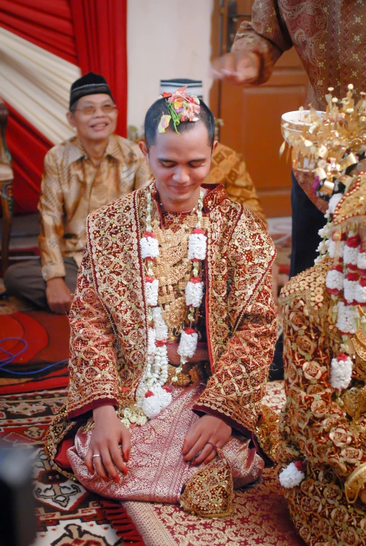 an asian man and woman sitting on a rug