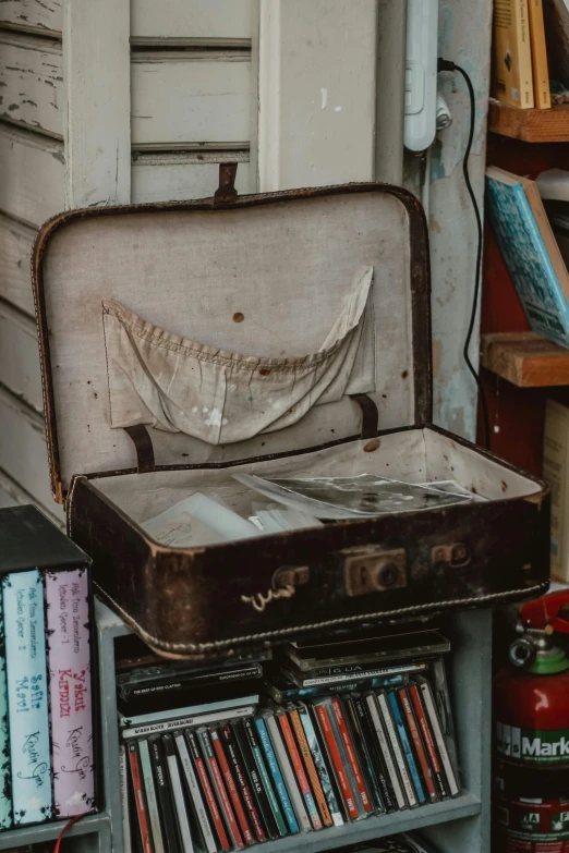 an old suitcase and bookcase full of records