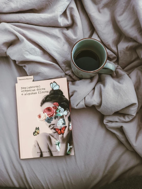 an image of a coffee mug and book on the bed