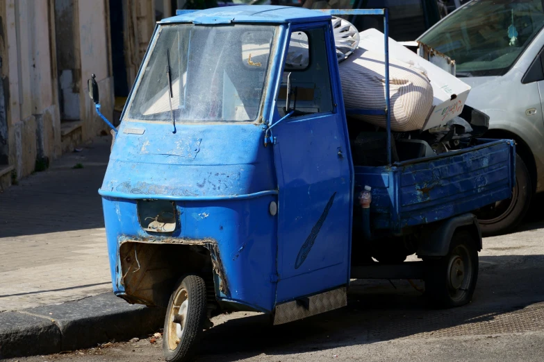 a blue pick up truck parked in front of another one