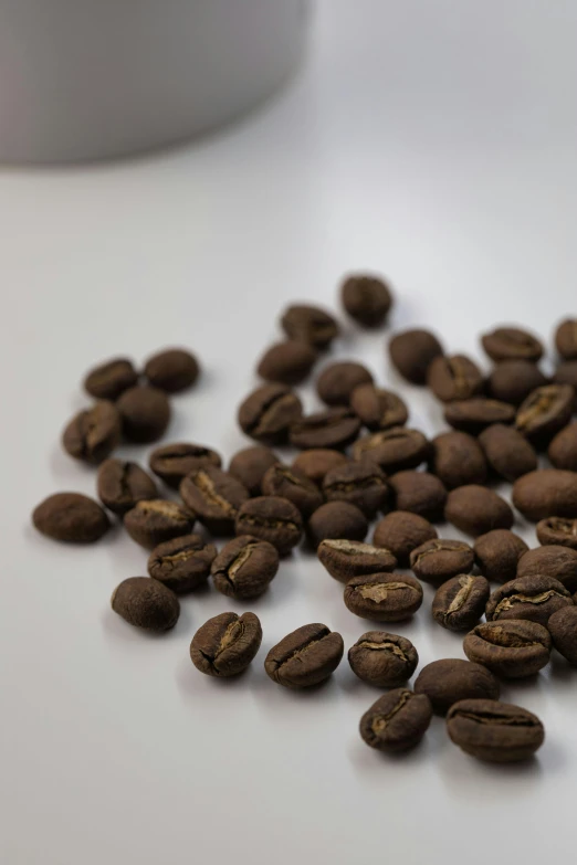 a pile of coffee beans sit on a white table