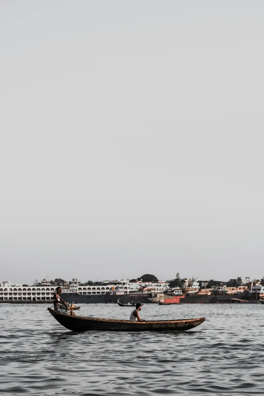 a man rows a small boat in the water