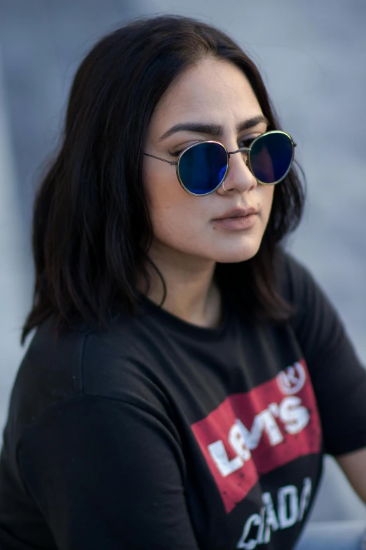 a woman is sitting outside with her sunglasses on