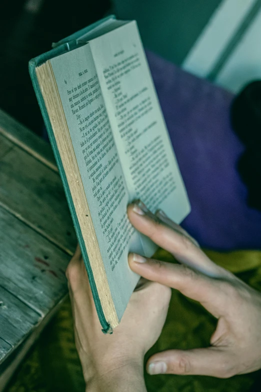 someone reading a book while holding it in their hand