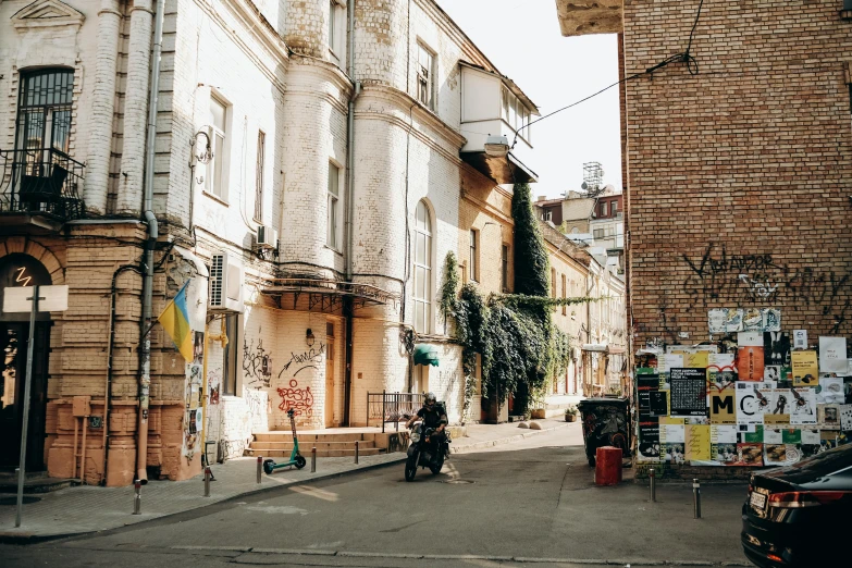 a city street with parked cars and a motorcycle parked on the side