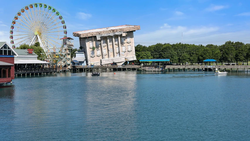 the ferris wheel is next to the building on the water