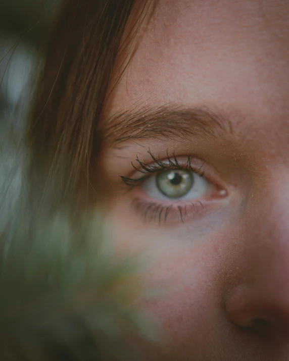 a woman looking through the window with green eyes