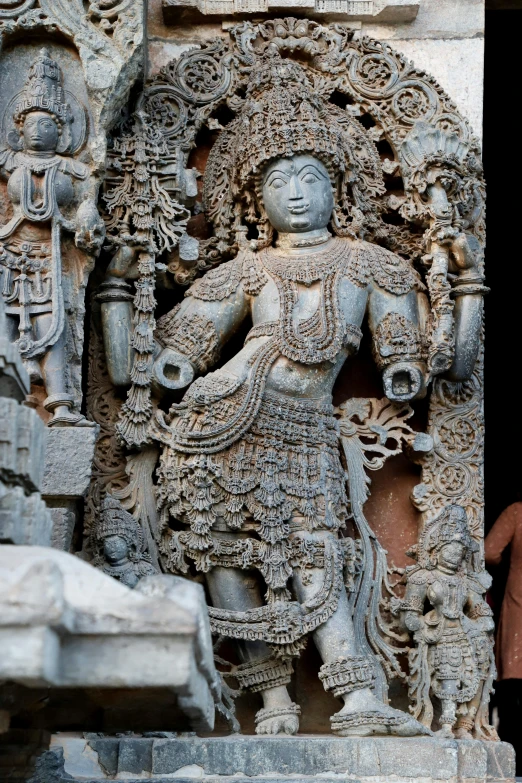 an elaborate indian stone statue and figurines decorate the wall