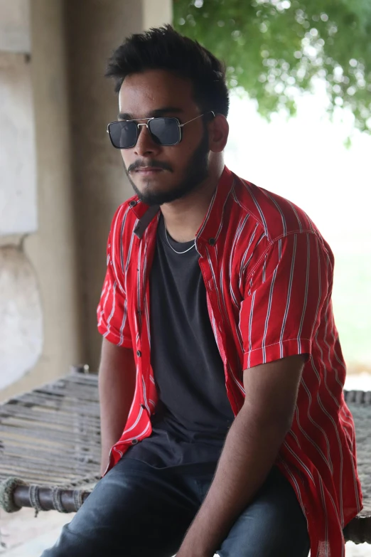 man sitting on a bench wearing glasses in front of him