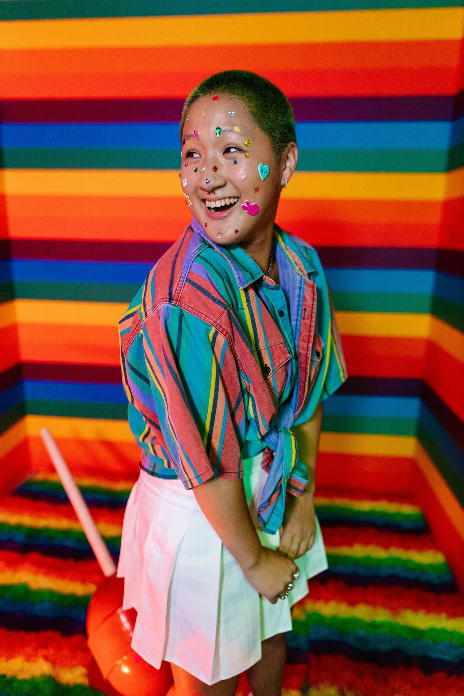 a girl is standing in a room painted with rainbows