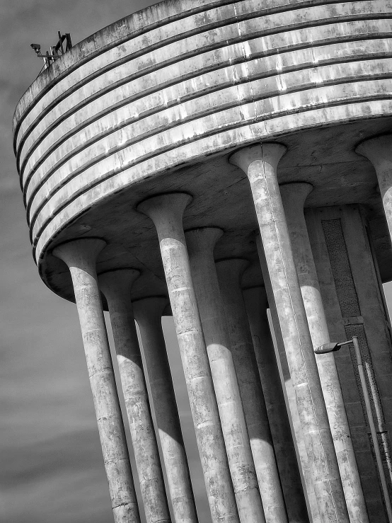 a tall building with pillars surrounding it and animals on the top