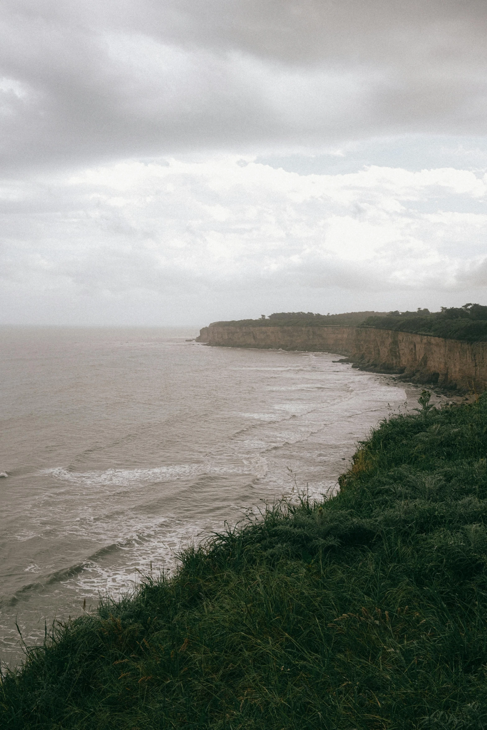 a train going over a hill by the ocean