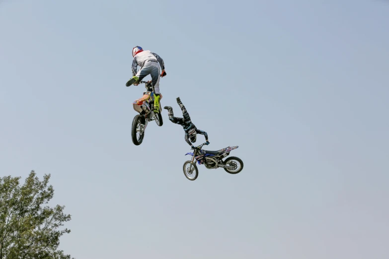 an adult on a motor bike jumps into the air