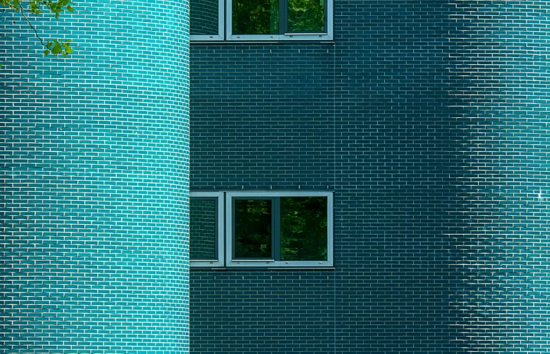 the building's front has a few windows, as well as the blue brick facade