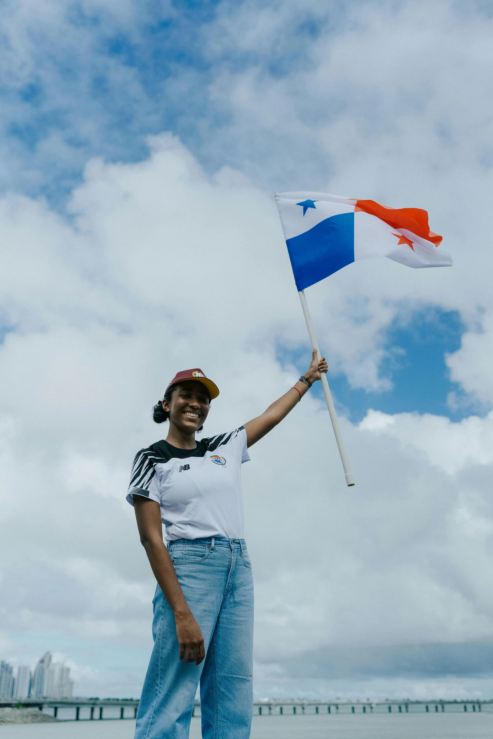 a woman holding a flag in front of a body of water