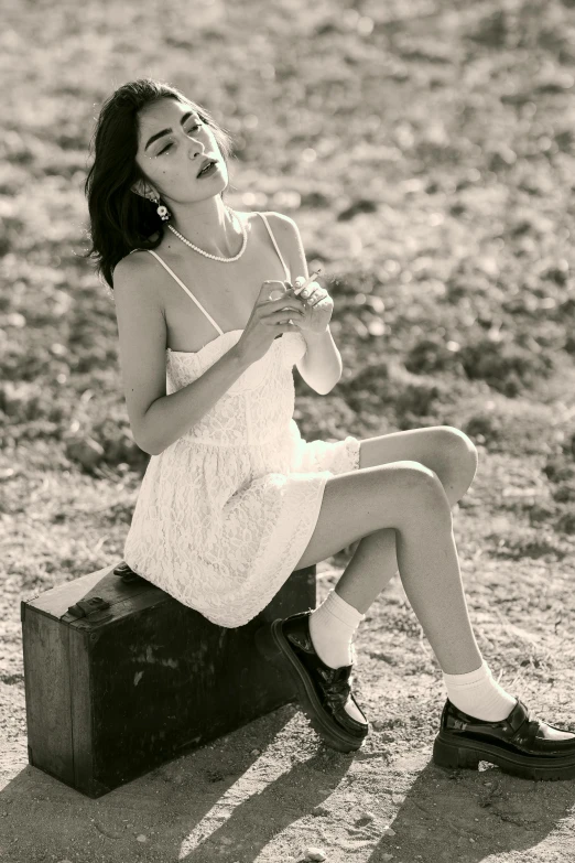 a girl sitting on suitcase looking up with her hand in her mouth