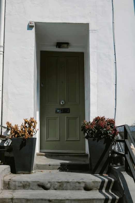 an open green door is displayed on a building