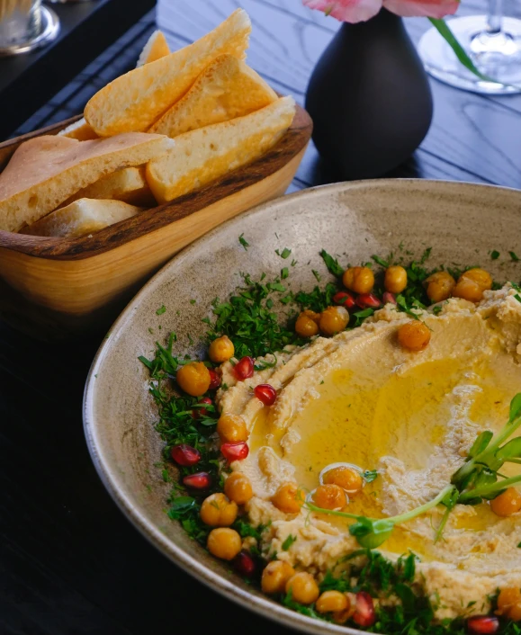 a bowl of hummus and french fries sitting next to an empty dish