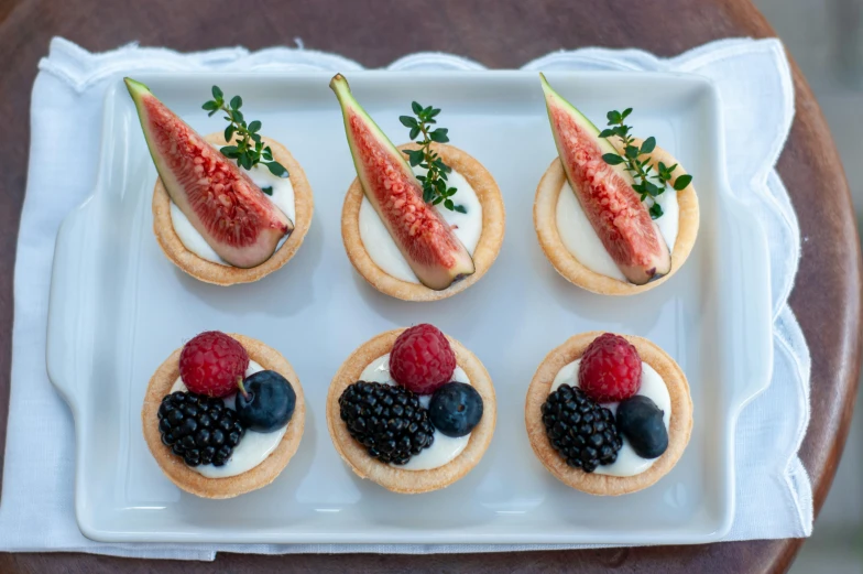 fruit and white chocolate cookie rounds on top of white frosted plates