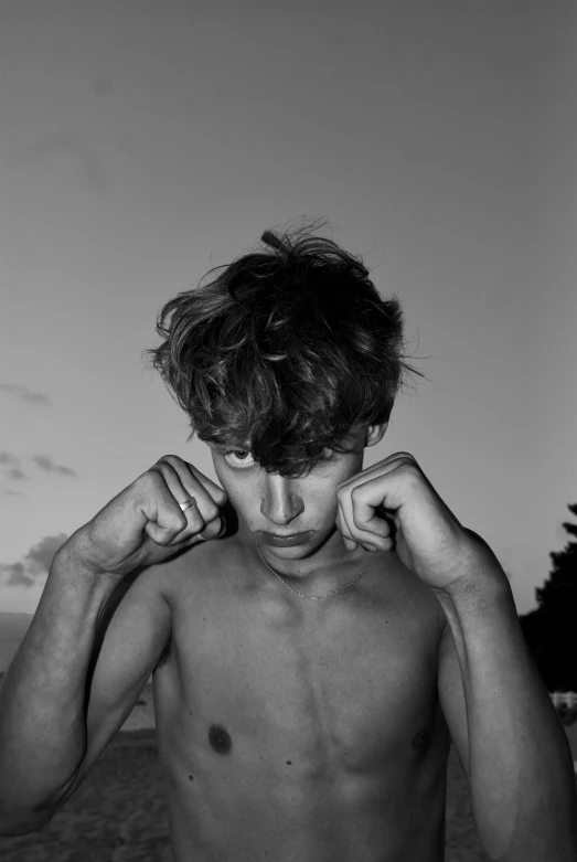 a black and white image of a young man, posing without his shirt